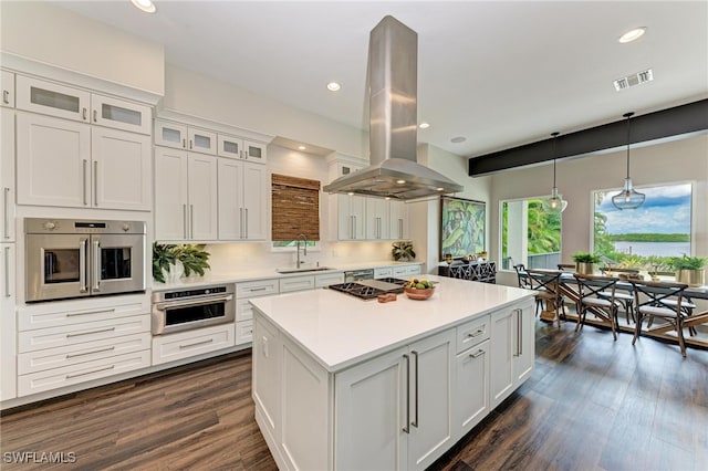 kitchen with white cabinets, island range hood, and a wealth of natural light