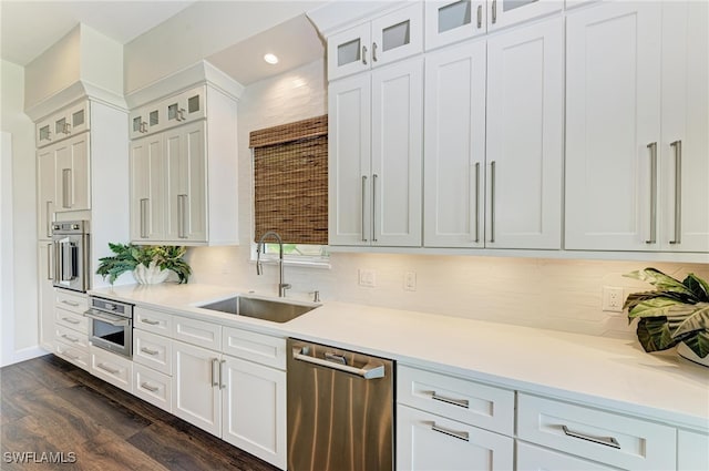 kitchen with sink, white cabinets, stainless steel appliances, backsplash, and dark hardwood / wood-style flooring