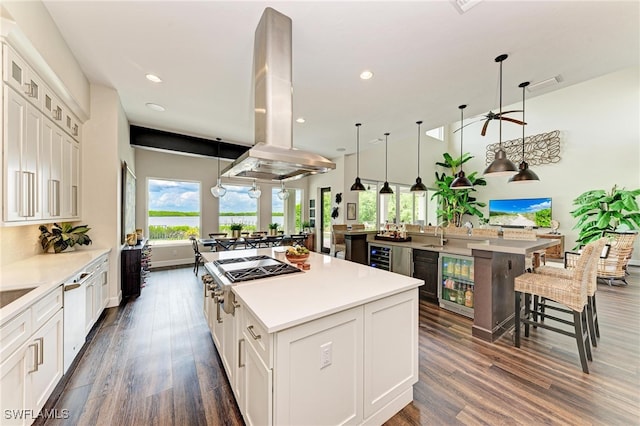 kitchen featuring a large island, white cabinets, island exhaust hood, and beverage cooler