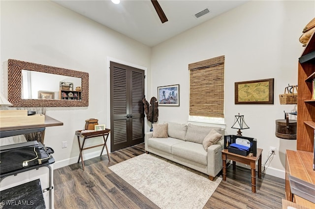 living room featuring ceiling fan and dark hardwood / wood-style flooring