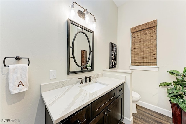 bathroom featuring vanity, hardwood / wood-style floors, and toilet