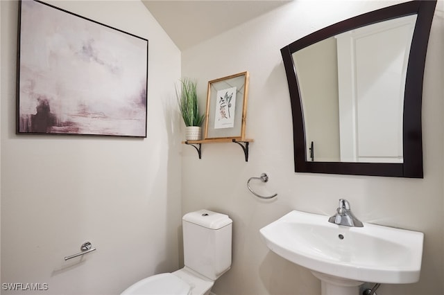 bathroom featuring vaulted ceiling, toilet, and sink