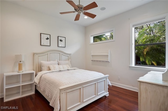 bedroom with ceiling fan, multiple windows, and dark hardwood / wood-style flooring