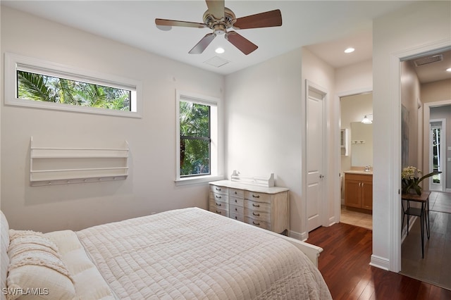 bedroom featuring ceiling fan, ensuite bathroom, dark wood-type flooring, and sink