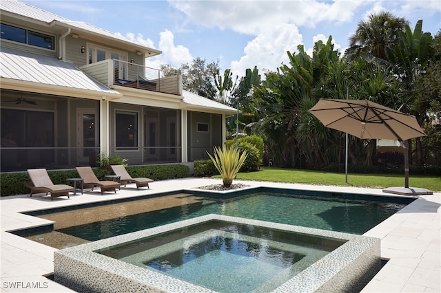 view of swimming pool with a patio, a lawn, an in ground hot tub, and a sunroom