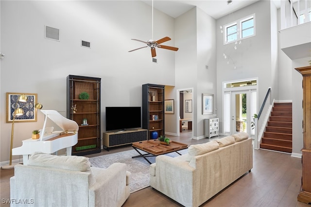 living room featuring a high ceiling, hardwood / wood-style flooring, and ceiling fan