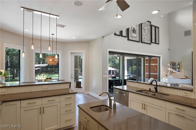 kitchen with dishwasher, sink, light wood-type flooring, and cream cabinetry