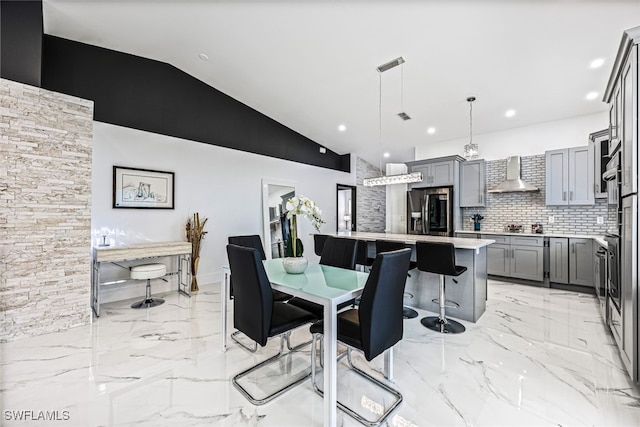 dining space featuring vaulted ceiling