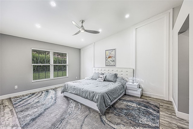 bedroom featuring ceiling fan, hardwood / wood-style flooring, and vaulted ceiling