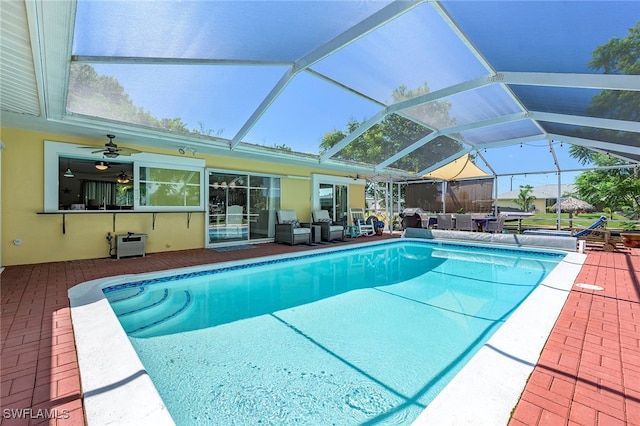 view of pool featuring a patio, ceiling fan, and glass enclosure