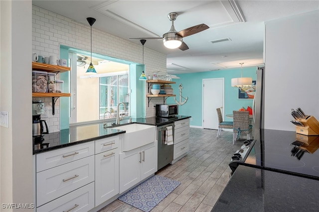 kitchen featuring appliances with stainless steel finishes, light hardwood / wood-style floors, white cabinetry, and pendant lighting