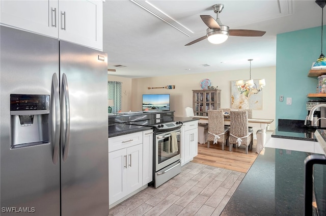 kitchen featuring light wood-type flooring, ceiling fan with notable chandelier, white cabinets, hanging light fixtures, and stainless steel appliances