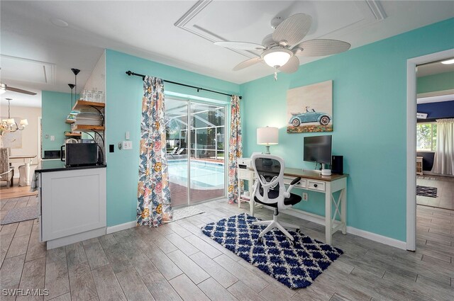 office with light wood-type flooring and ceiling fan