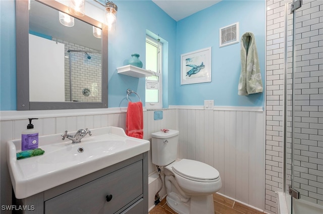 bathroom with walk in shower, hardwood / wood-style floors, vanity, and toilet