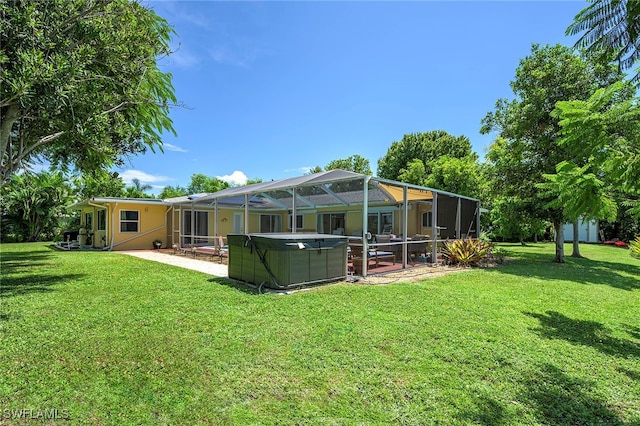 back of property featuring a patio, glass enclosure, and a yard