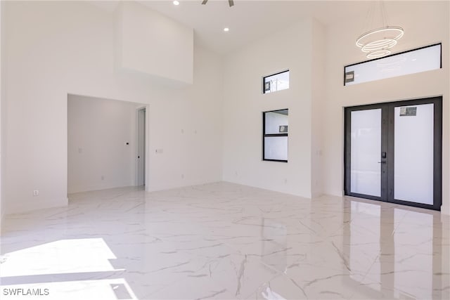 empty room with a towering ceiling and french doors