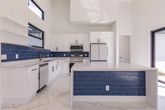 kitchen with white cabinets, stainless steel appliances, and a wealth of natural light