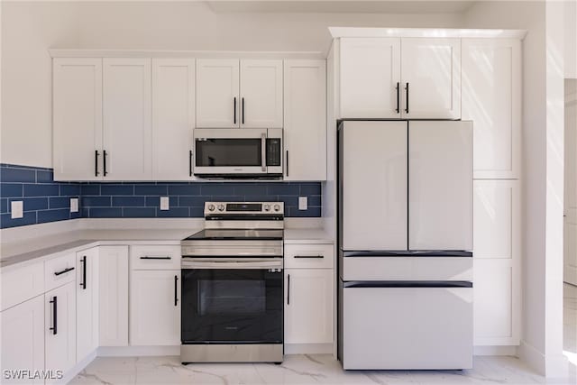 kitchen featuring white cabinets, appliances with stainless steel finishes, and backsplash