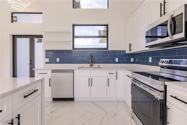 kitchen with backsplash, sink, stainless steel appliances, and white cabinets