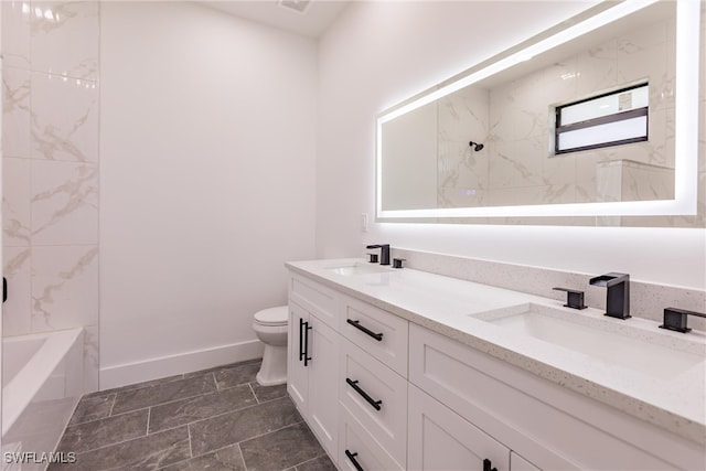 full bathroom with tiled shower / bath, vanity, and toilet