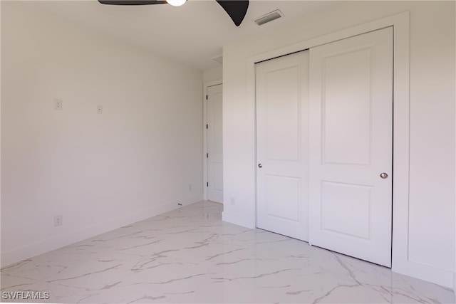 unfurnished bedroom featuring ceiling fan and a closet