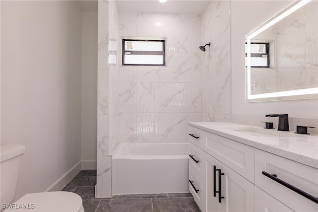 full bathroom featuring tiled shower / bath, vanity, and toilet