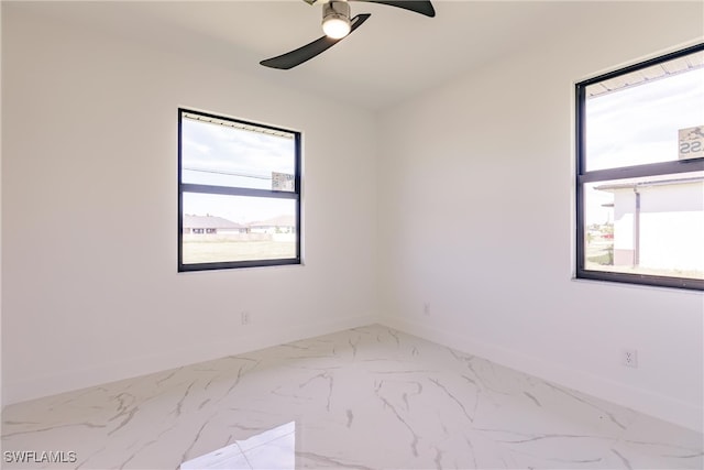 spare room featuring ceiling fan and a wealth of natural light