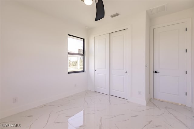 unfurnished bedroom with ceiling fan and a closet