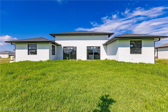 rear view of property featuring a yard