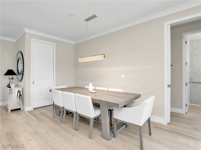 dining space featuring light hardwood / wood-style flooring and ornamental molding