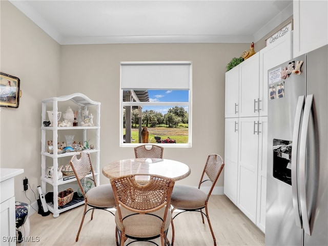 dining space featuring light hardwood / wood-style flooring and ornamental molding