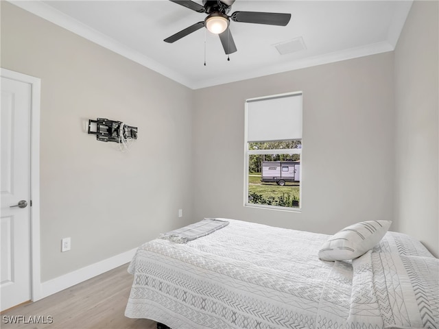 bedroom with ceiling fan, light hardwood / wood-style flooring, and ornamental molding