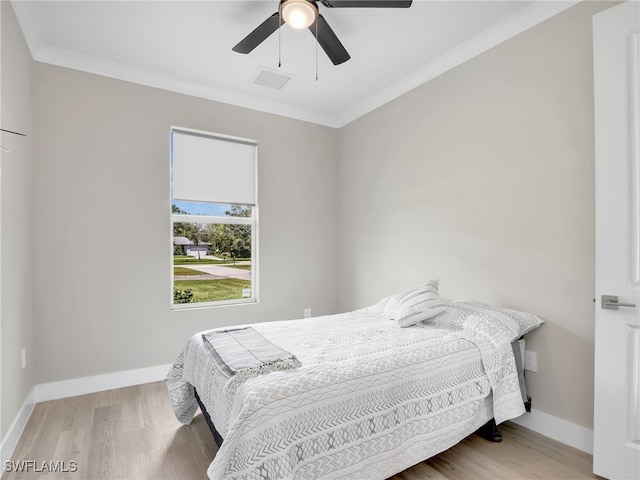 bedroom featuring wood-type flooring, crown molding, and ceiling fan