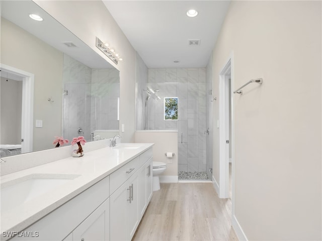 bathroom with vanity, toilet, a shower with door, and hardwood / wood-style flooring