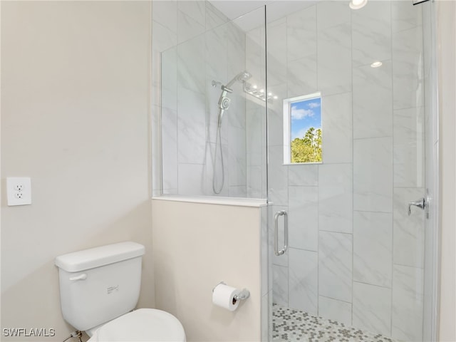 bathroom with a shower with door and toilet