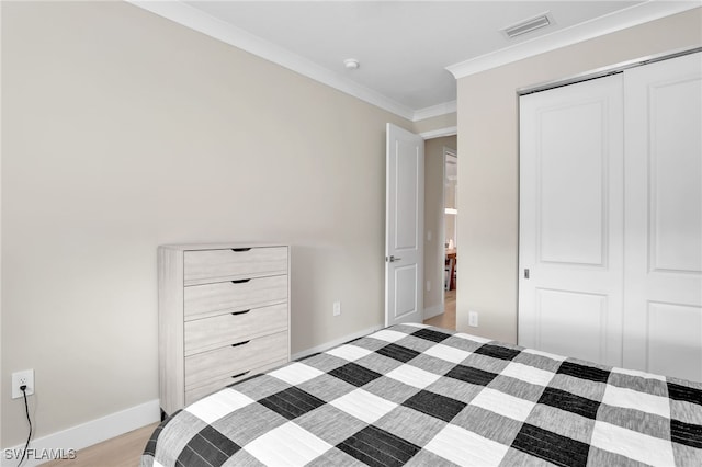 bedroom with crown molding and a closet