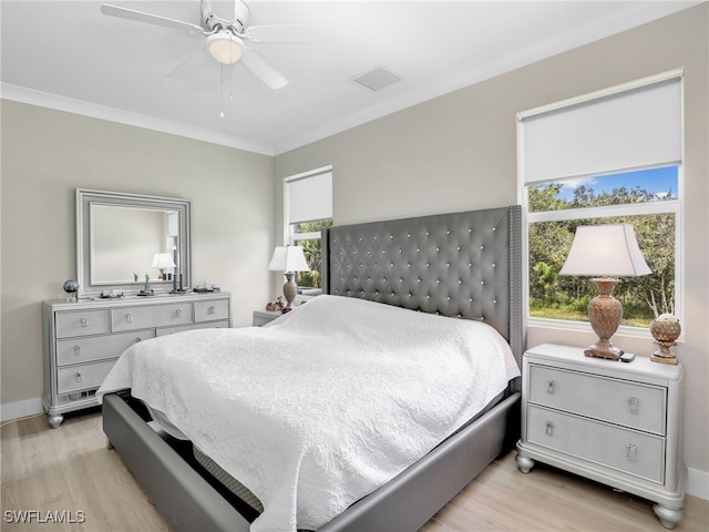 bedroom with light hardwood / wood-style floors, ceiling fan, and crown molding