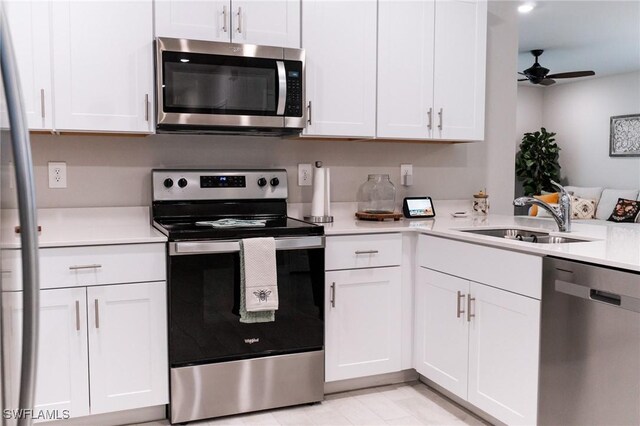 kitchen with ceiling fan, white cabinets, stainless steel appliances, and sink