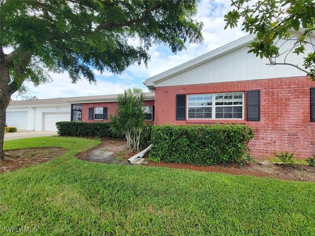 single story home featuring a garage and a front lawn