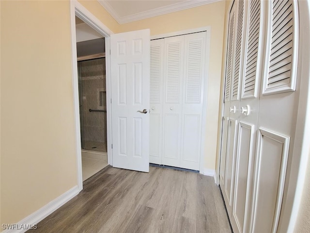 hall with light hardwood / wood-style flooring and ornamental molding