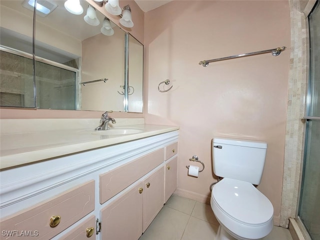 bathroom featuring tile patterned flooring, vanity, toilet, and walk in shower