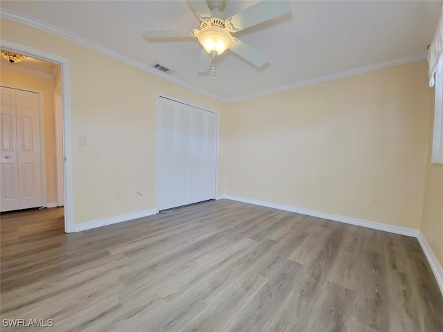 unfurnished bedroom with light wood-type flooring, a closet, ceiling fan, and crown molding