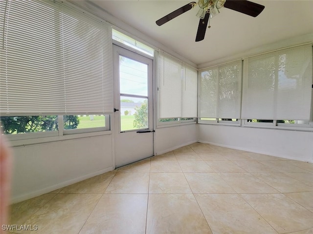 unfurnished sunroom featuring ceiling fan and a healthy amount of sunlight