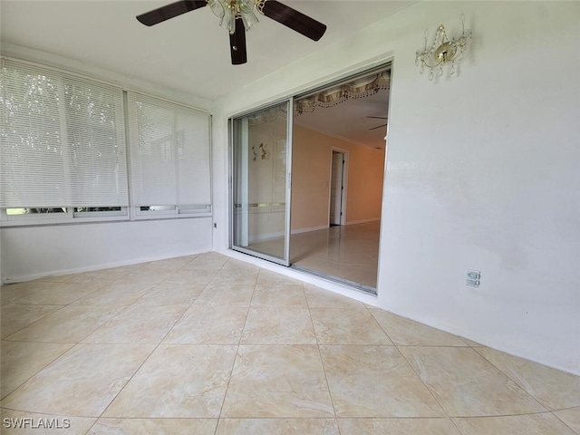 tiled empty room featuring ceiling fan