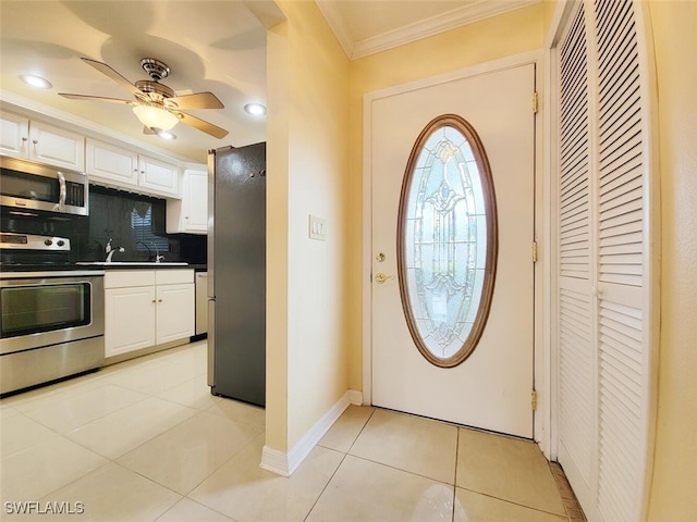 interior space featuring light tile patterned floors, ceiling fan, crown molding, and sink