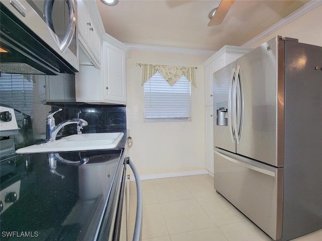 kitchen with stainless steel appliances, light tile patterned floors, tasteful backsplash, crown molding, and white cabinets