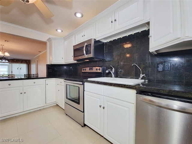 kitchen with white cabinetry, backsplash, appliances with stainless steel finishes, and ornamental molding