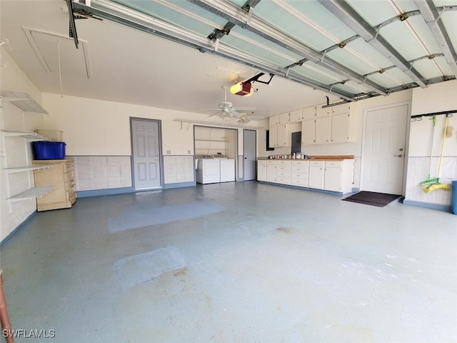 garage with ceiling fan, washing machine and dryer, and a garage door opener