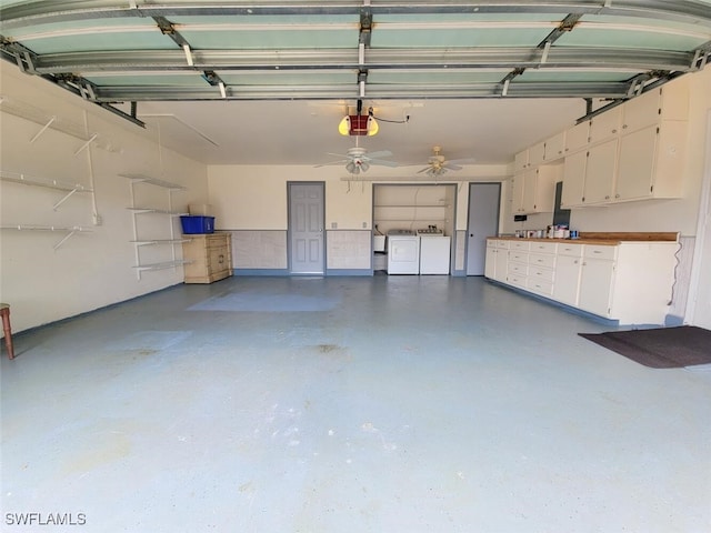 garage with a garage door opener, ceiling fan, and washing machine and clothes dryer