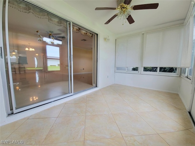 unfurnished sunroom featuring ceiling fan